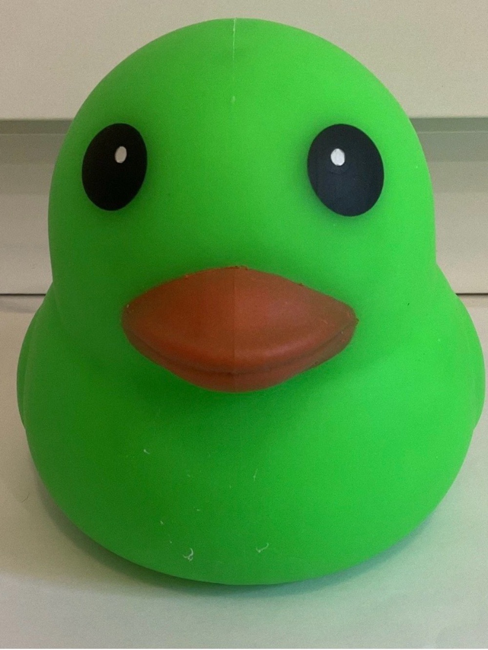 This is a bright green jumbo squishy duck stress toy, commonly known as a Laffy